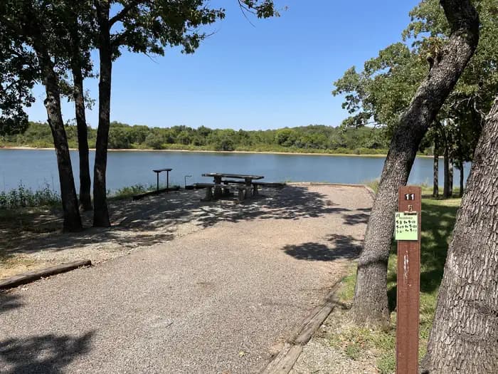 A photo of Site 11 of Loop JCRE at JOHNSON CREEK with Picnic Table, Electricity Hookup, Fire Pit, Shade, Waterfront, Water Hookup