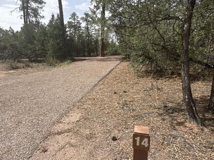 Houston Mesa, Elk Loop site #14 featuring parking, entrance to the wooded site, and picnic table.